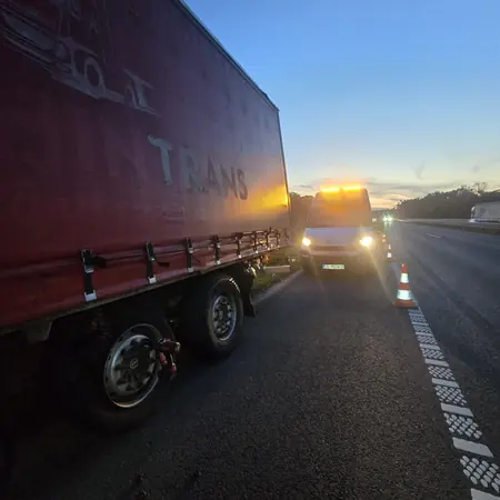Intervencija na poluprikolici u sumrak, uz postavljene čunjeve i rotacijska svjetla
