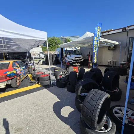 Servis guma za trkaće automobile u paddocku, uz zastavu Moon Mobility Tyres