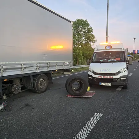 Zamjena kotača na poluprikolici u sumrak, uz servisno vozilo